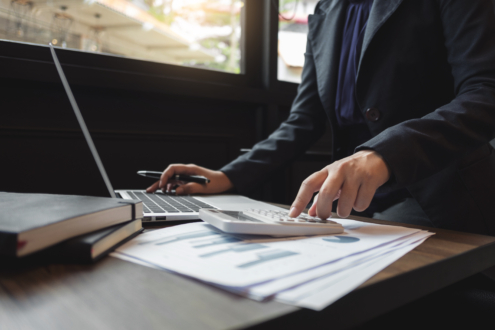 Buchhalterin arbeitet mit digitalen Dokumenten und Taschenrechner – automatisierte Buchhaltung im Büro